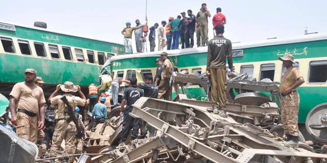 Pakistani officials and volunteers work at a train crash site in Rahim Yar Khan, Pakistan.