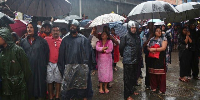 Nepalese people watch army soldiers rescuing people from their flooded homes in Kathmandu on Friday. (AP Photo/Niranjan Shrestha)