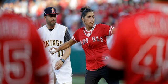 The late Los Angeles Angels pitcher Tyler Skaggs' mother, Debbie Hetman, center in red, throws the game's ceremonial first pitch, at a baseball game between the Angels and the Seattle Mariners on Friday, July 12, 2019, in Anaheim, Calif. (Associated Press)