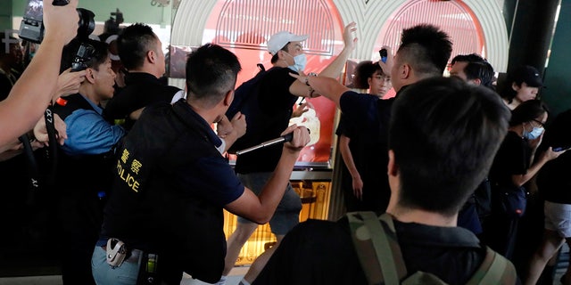 Police attack a protester in Hong Kong Saturday, July 13, 2019. Several thousand people marched in Hong Kong on Saturday against traders from mainland China in what is fast becoming a summer of unrest in the semi-autonomous Chinese territory. (AP Photo/Kin Cheung)