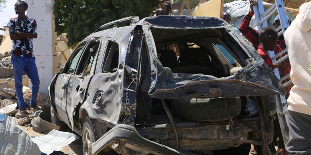 A view of a car destroyed during an attack at the Asasey Hotel, in Kismayo, Somalia, Saturday July 13, 2019. At least 10 people, including two journalists, were killed in an extremist attack Friday on a hotel in the port city of Kismayo, a Somali official said. The attack started with a suicide car bomb blast and then gunmen stormed into the hotel. (AP Photo)