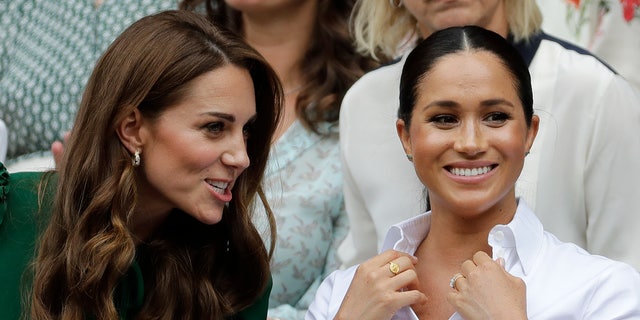 Kate, the Duchess of Cambridge, left, and Meghan, the Duchess of Sussex, argue while they watch Serena Williams play Simona Halep. 
