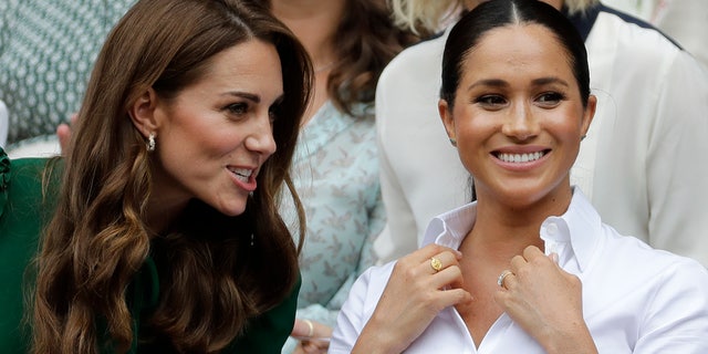 Kate, Duchess of Cambridge, left, and Meghan, Duchess of Sussex, chat as they watch Serena Williams play Simona Halep.