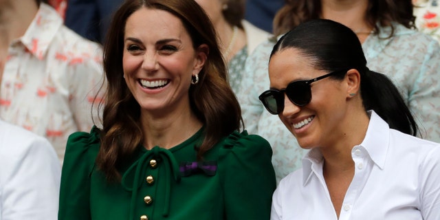 Kate, Duchess of Cambridge and Meghan, Duchess of Sussex, right, stand together during the women's singles final match on day twelve of the Wimbledon Tennis Championships in London, on July 13, 2019. (AP Photo/Ben Curtis)