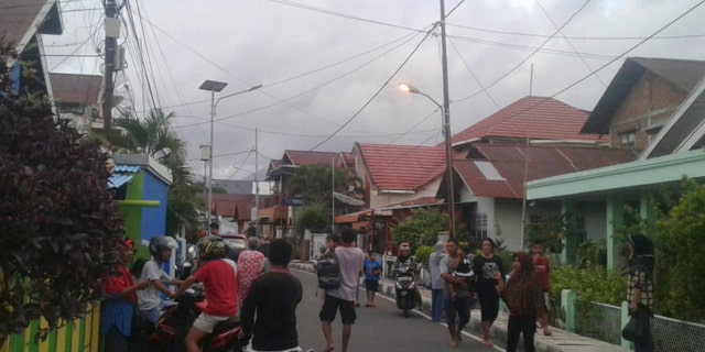 Residents leave their homes to find higher grounds following an earthquake in Ternate, North Maluku, Indonesia on Sunday. (AP Photo)