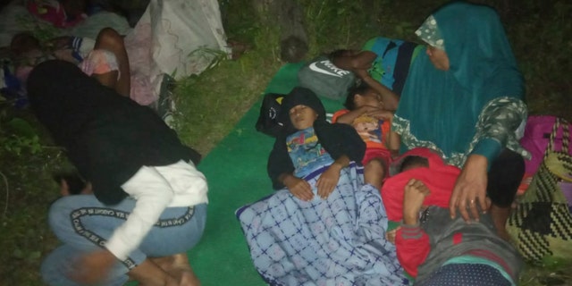 Residents sleep on the ground after leaving their homes to find higher grounds following an earthquake in Gane Utara, North Maluku, Indonesia on Sunday. (AP Photo)