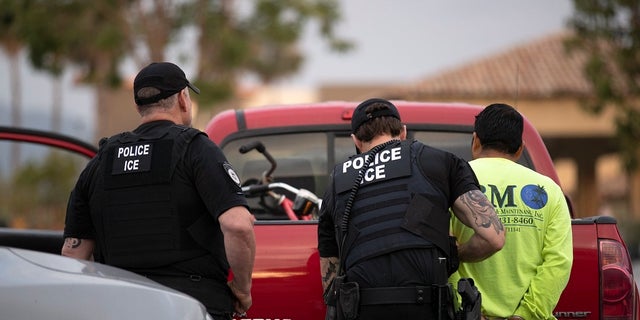 In this July 8, 2019, photo, U.S. Immigration and Customs Enforcement (ICE) officers detain a man during an operation in Escondido, Calif. (AP Photo/Gregory Bull)