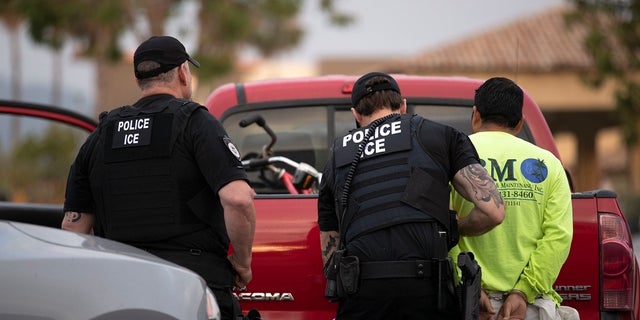 In this July 8, 2019, photo, U.S. Immigration and Customs Enforcement (ICE) officers detain a man during an operation in Escondido, Calif. (AP Photo/Gregory Bull)