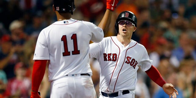 Boston Red Sox's Brock Holt celebrates with Rafael Devers (11) after scoring on a two-run single by Mookie Betts during the fifth inning of a baseball game against the Toronto Blue Jays in Boston, Tuesday, July 16, 2019.