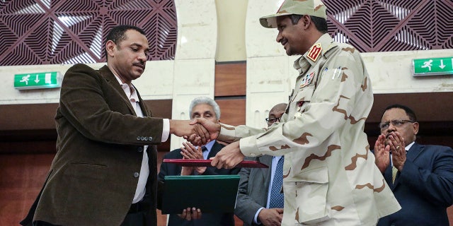Gen. Mohammed Hamdan Dagalo, right, and Sudan's pro-democracy movement leader Ahmad al-Rabiah shake hands after signing a power-sharing document in Khartoum, Sudan, Wednesday, July 17, 2019.