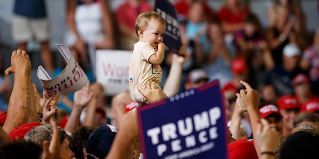 A baby is held high in the audience as President Donald Trump speaks at a campaign rally at Williams Arena in Greenville, N.C., Wednesday, July 17, 2019. (AP Photo/Carolyn Kaster)