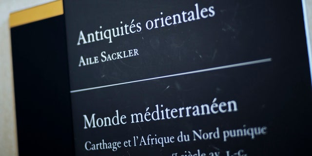 A sign reads "Oriental Antiquities, Sackler wing" at the Louvre Museum in Paris, France, Wednesday, July 17, 2019. France's Louvre museum has taped over the Sackler name as donors to a wing of the building after protests against the family blamed for the opioid crisis in the United States. (AP Photo/Kamil Zihnioglu)