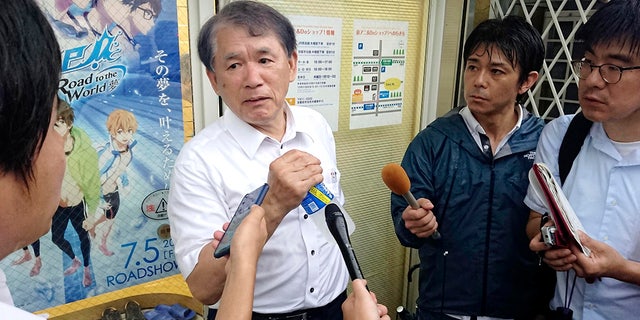 Hideaki Hatta, center, president of Kyoto Animation speaks to the media at the company's headquarters, following a fire of his company's building, in Uji, Kyoto prefecture, western Japan, Thursday, July 18, 2019. The fire broke out in the three-story building in Japan's ancient capital of Kyoto, after a suspect sprayed an unidentified liquid to accelerate the blaze, Kyoto prefectural police and fire department officials said.(Kyodo News via AP)