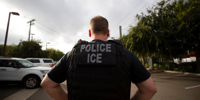 FILE - In this July 8, 2019, file photo, a U.S. Immigration and Customs Enforcement (ICE) officer looks on during an operation in Escondido, Calif. Advocacy groups and unions are pressuring Marriott, MGM and others not to house migrants who have been arrested by U.S. Immigration and Customs Enforcement agents. But the U.S. government says it sometimes needs bed space, and if hotels don’t help it might have to split up families. (AP Photo/Gregory Bull, File)