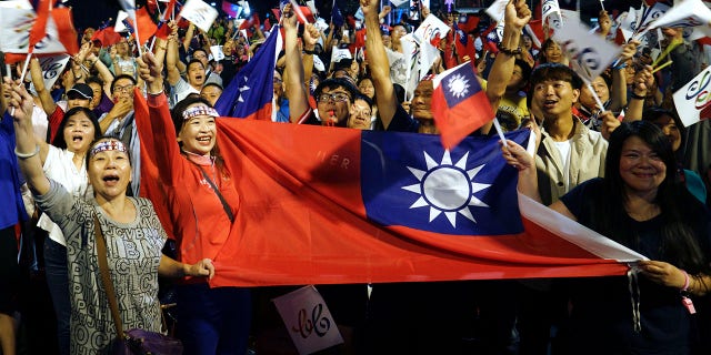 In this Nov. 24, 2018, file photo, supporters of the opposition Nationalist Party cheer in Kaohsiung, Taiwan. 