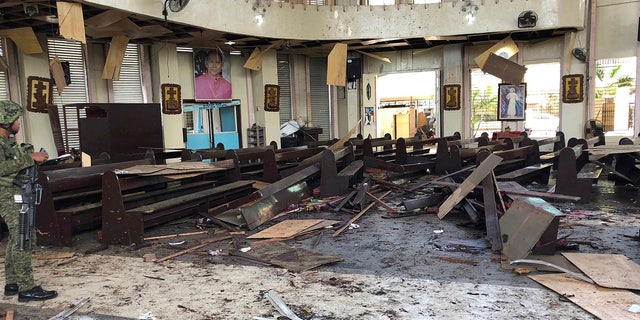 In this Jan. 27, 2019, file photo provided by WESMINCOM Armed Forces of the Philippines, a soldier views the site inside a Roman Catholic cathedral in Jolo, the capital of Sulu province in the southern Philippines, after two bombs exploded. Police said Tuesday, July 23, 2019, they believe an Indonesian husband and wife carried out the suicide bombing of a cathedral in the southern Philippines in January that killed more than 20 people.