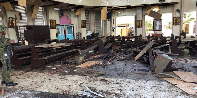 In this Jan. 27, 2019, file photo provided by WESMINCOM Armed Forces of the Philippines, a soldier views the site inside a Roman Catholic cathedral in Jolo, the capital of Sulu province in the southern Philippines, after two bombs exploded. Police said Tuesday, July 23, 2019, they believe an Indonesian husband and wife carried out the suicide bombing of a cathedral in the southern Philippines in January that killed more than 20 people.