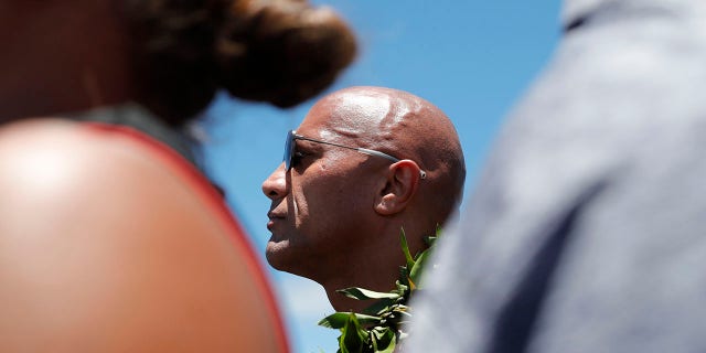 Actor Dwayne "The Rock" Johnson stands during a prayer during a visit to the protests against the TMT telescope, Wednesday, July 24, 2019, at the base of Mauna Kea on Hawaii Island. (Jamm Aquino/Honolulu Star-Advertiser via AP)