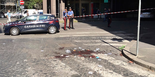Two Italian Carabinieri, paramilitary police officers, stand near a blood stain, the site where their colleague, Carabiniere Vice Brigadier Mario Cerciello Rega, was stabbed to death by a thief in Rome. (Associated Press)