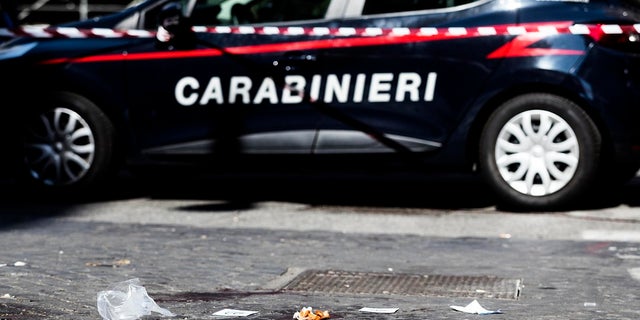 A car of the Italian Carabinieri, paramilitary police, is parked near a blood stain, the site where Carabiniere Vice Brigadier Mario Cerciello Rega was stabbed to death by a thief in Rome on Friday. (Angelo Carconi/ANSA Via AP)