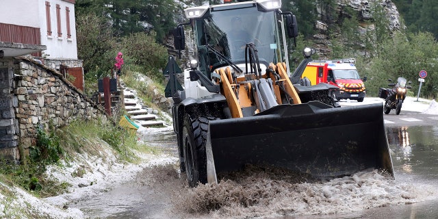 A worker uses a digger to clean the road of the nineteenth stage of the Tour de France cycling race over 126,5 kilometers (78,60 miles) with start in Saint Jean De Maurienne and finish in Tignes, France, Friday, July 26, 2019. Tour de France organizers stopped Stage 19 of the race because of a hail storm as Julien Alaphilippe lost his yellow jersey to Egan Bernal. (AP Photo/Thibault Camus)