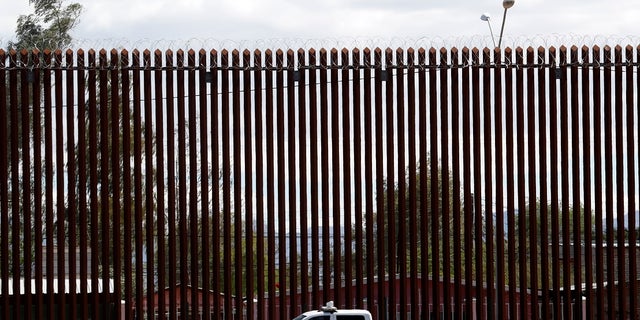 In this April 5, 2019 file photo, a U.S. Customs and Border Protection vehicle stands near the wall as President Donald Trump visits a new section of the border wall with Mexico in El Centro, California.