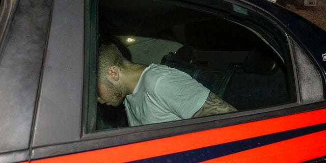 A man who was allegedly questioned in the case of a slain Carabinieri policeman is seen on a Carabinieri car as it leaves a police station, in Rome, early Saturday morning, July 27, 2019. A young American tourist has confessed to fatally stabbing an Italian paramilitary policeman who was investigating the theft of a bag and cellphone before dawn Friday, the Italian news agency ANSA and state radio reported. (AP Photo/Andrew Medichini)
