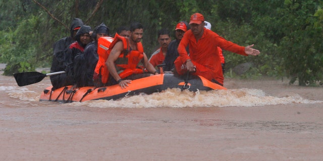 Members of the National Disaster Response Force (NDRF) work to rescue passengers of a stranded train in Badlapur, India Saturday, July 27, 2019. Rescuers in India on Saturday safely evacuated all 700 passengers from a train after it got stuck in monsoon floodwaters between two stations near Mumbai, the country's home minister said. A statement by India's disaster management office in Maharashtra state said the Mahalaxmi Express train got stuck due to flooding of the tracks. (AP Photo/Rafiq Maqbool)