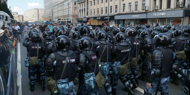 Police block a street during an unsanctioned rally in the center of Moscow during a protest on Saturday. (AP Photo/ Pavel Golovkin)