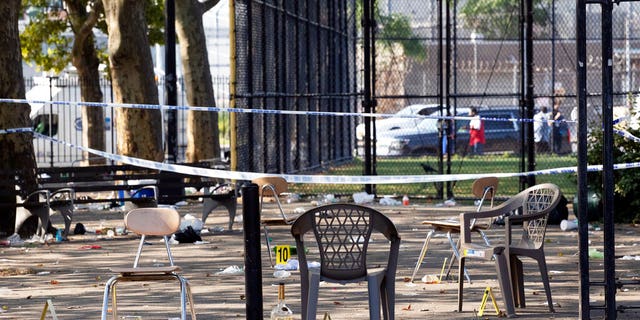Yellow evidence markers are placed next to chairs at a playground in the Brownsville neighborhood in the Brooklyn borough of New York on Sunday.