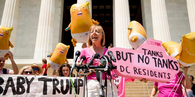 Activist Medea Benjamin, co-founder of the anti-war group Code Pink, holding a sign that reads "Tanks But No Tanks DC Residents," in Washington on Tuesday. (AP Photo/Andrew Harnik)