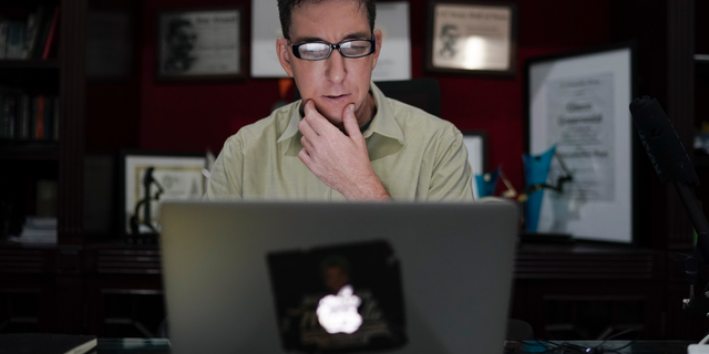 In this July 10, 2019 photo, U.S. journalist Glenn Greenwald checks his news website at his home in Rio de Janeiro, Brazil. (AP Photo/Leo Correa)