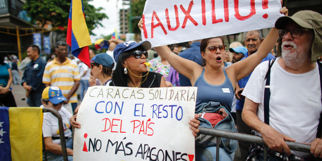People protest a day after a massive blackout as they gather for a rally called by self-proclaimed interim president of Venezuela Juan Guaido, in Caracas, July 23, 2019. (AP Photo/Ariana Cubillos)