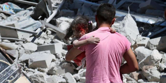 This Saturday, July 27, 2019 file photo shows a Syrian man carrying an injured girl after an airstrike hit the northern town of Ariha, in Idlib province, Syria. Syrian opposition activists and a war monitor said Sunday, July 28, 2019, that five people had been killed in airstrikes on Ariha on Sunday as the government keeps up its deadly air campaign against the rebel-controlled region. (Syrian Civil Defense White Helmets via AP, File)