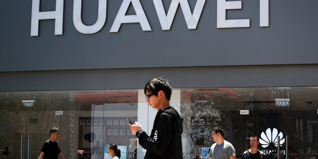 People walk past a Huawei retail store in Beijing on June 30, 2019. (AP Photo/Andy Wong)