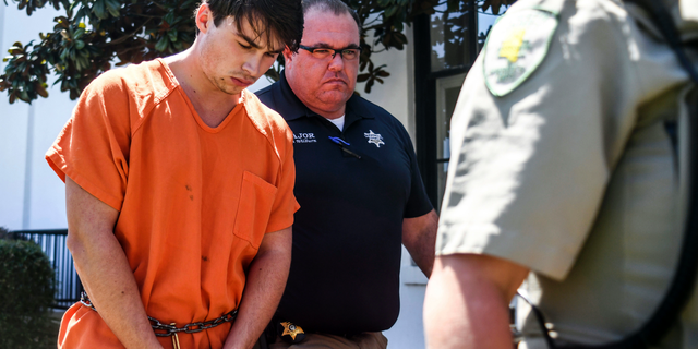Brandon Theesfeld, left, is led from the Lafayette County Courthouse in Oxford, Miss., Tuesday, July 23, 2019, after being arraigned in connection with the death of 21-year-old University of Mississippi student Alexandria