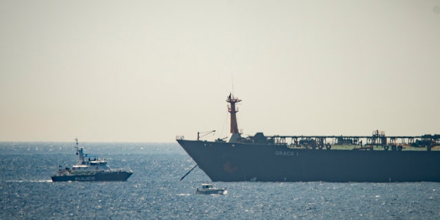 A view of the Grace 1 supertanker near a Royal Marine patrol vessel in the British territory of Gibraltar, Thursday, July 4, 2019. Spain's acting foreign minister says a tanker stopped off Gibraltar and suspected of taking oil to Syria was intercepted by British authorities after a request from the United States. (AP Photo/Marcos Moreno)
