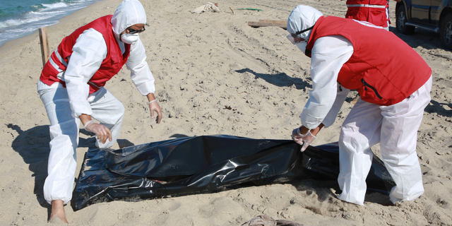 Libyan Red Crescent workers pick up a body of a drowned migrant near the city of Khoms, some 100 kilometers (60 miles) east of Tripoli, Libya, Friday, July 26, 2019. Libya's coast guard recovered dozens of bodies of Europe-bound migrants who perished at sea as search operations continued Friday, a day after up to 150 people, including women and children, went missing and were feared drowned after their boats capsized in the Mediterranean Sea. (AP Photo/Hazem Ahmed)