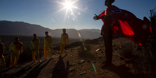 A youth dressed as a shaman arrives to take part in a photo session before Tuesday's total solar eclipse, in La Higuera, Chile, Monday, July 1, 2019.