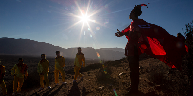 A youth dressed as a shaman arrives to take part in a photo session before Tuesday's total solar eclipse, in La Higuera, Chile, Monday, July 1, 2019.
