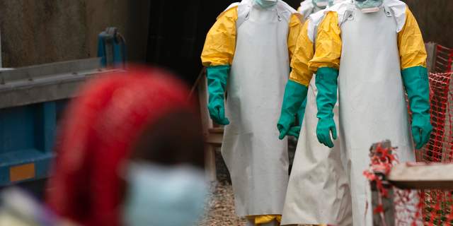 In this Tuesday, July 16, 2019 photo, health workers dressed in protective gear begin their shift at an Ebola treatment center in Beni, Congo DRC. The World Health Organization has declared the Ebola outbreak an international emergency after spreading to eastern Congo's biggest city, Goma, this week. More than 1,600 people in eastern Congo have died as the virus has spread in areas too dangerous for health teams to access. (AP Photo/Jerome Delay)