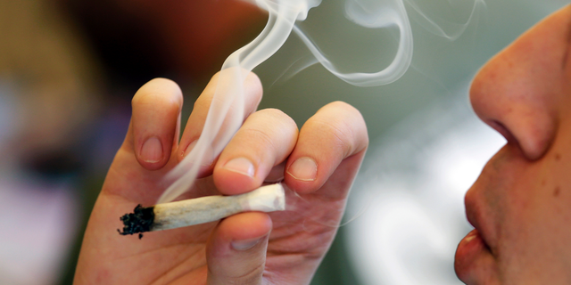 FILE PHOTO: A man smokes a marijuana joint at a party in Seattle, Washington.