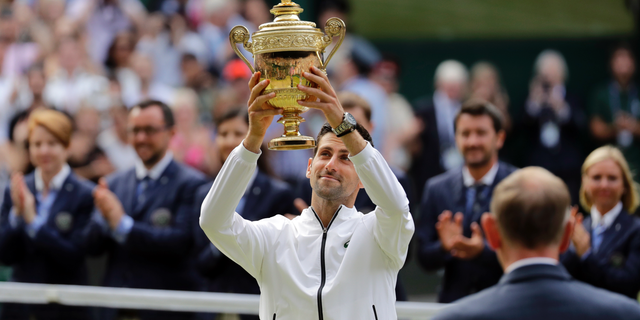 Serbia's Novak Djokovic lifts his trophy after defeating Switzerland's Roger Federer during the men's singles final match of the Wimbledon Tennis Championships in London, Sunday, July 14, 2019. (AP Photo/Ben Curtis)