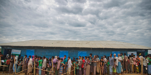 In this Nov. 15, 2017, file photo, Rohingya Muslims, who crossed over from Myanmar into Bangladesh, wait in queues to receive aid at Kutupalong refugee camp in Ukhiya, Bangladesh.