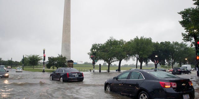 Heavy rainfall flooded the intersection of 15th Street and Constitution Ave., NW stalling cars in the street, Monday, July 8, 2019, in Washington near the Washington Monument.