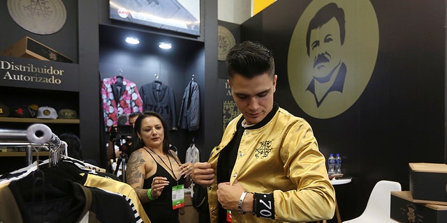 A man tries a jacket from the new "El Chapo 701" line, produced by the drug lord's daughter, Alejandrina Guzman.