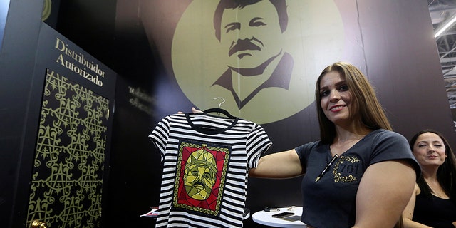 A woman holds up a shirt from the new "El Chapo 701" brand, produced by the drug lord's daughter, Alejandrina Guzman.