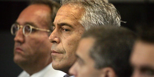 In this July 30, 2008 file photo, Jeffrey Epstein, center, is shown in custody in West Palm Beach, Fla.