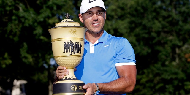 Brooks Koepka holds his trophy after winning the World Golf Championships-FedEx St. Jude Invitational Sunday, July 28, 2019, in Memphis, Tenn. (AP Photo/Mark Humphrey)