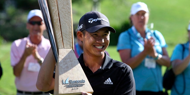 Collin Morikawa holds up his trophy for the gallery after winning the Barracuda Championship golf tournament at Montreux Golf & Country Club in Reno, Nev., Sunday, July 28, 2019. (AP Photo/ Lance Iversen)